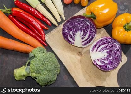 Purple cauliflower on cutting board with various vegetables on wooden background,Food background