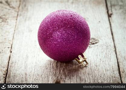 Purple Christmas bauble on old wood background