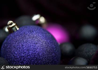 Purple Christmas decoration baubles against black background
