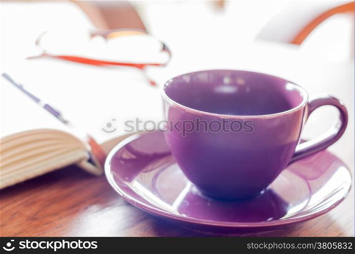 Purple coffee cup on wooden table, stock photo