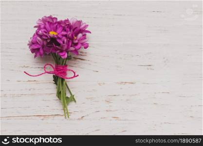 purple flowers tied white wooden surface. Resolution and high quality beautiful photo. purple flowers tied white wooden surface. High quality and resolution beautiful photo concept