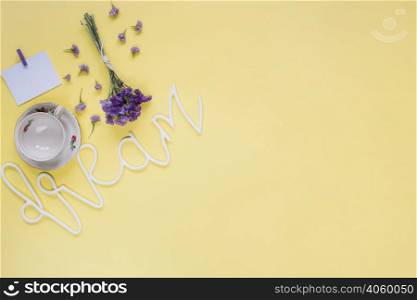 purple flowers with dream word empty cup yellow surface