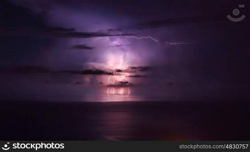 Purple lightning over the sea, powerful thunderbolt, amazing night landscape, stormy weather in the sea, beautiful natural wallpaper