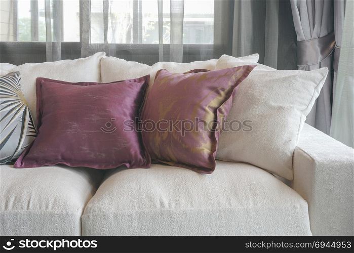 Purple pillows on white sofa in living room