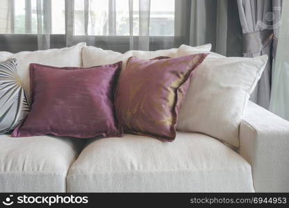 Purple pillows on white sofa in living room