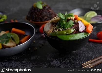 Purple rice berries with beans, carrot and mint leaves in a bowl