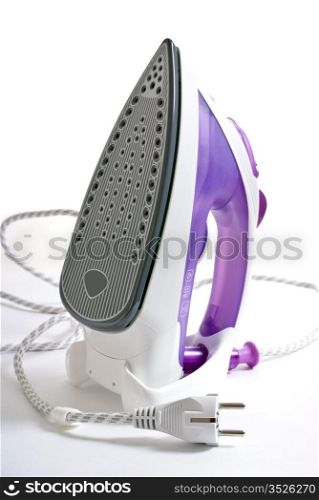purple smoothing iron standing on a white table
