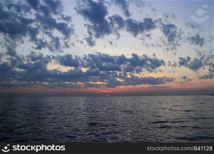purple sunset dramatic seascape, sun drowned in the sea, panorama