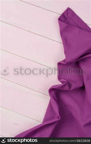 Purple towel over wooden kitchen table. View from above.