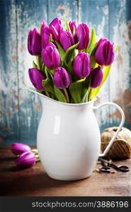 Purple Tulips, garden tools and easter eggs on a wooden surface. Studio photography