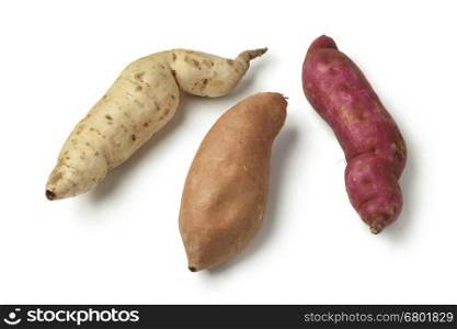 Purple, white and orange sweet potatoes on white background