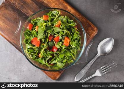 Pursla≠salad with tomatoes in a glass bowl. Hea<hy eating concept