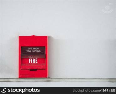 Push button switch, fire alarm on grey wall for alarm and security system with fire extinguisher port.