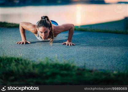 Push-Ups. Woman Exercising Outdoors by The Lake. Woman Exercising by The Lake  