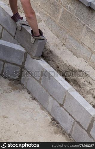 Putting bricks on a constructed wall outdoors