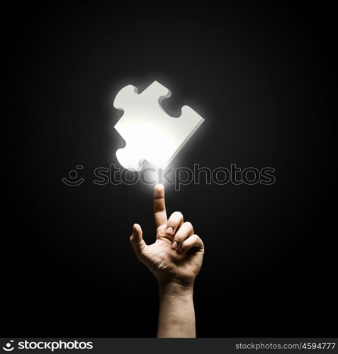 Puzzle element. Human hand pointing with finger at puzzle element