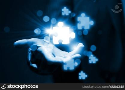 Puzzle elements. Close up of business person holding puzzle elements in hand