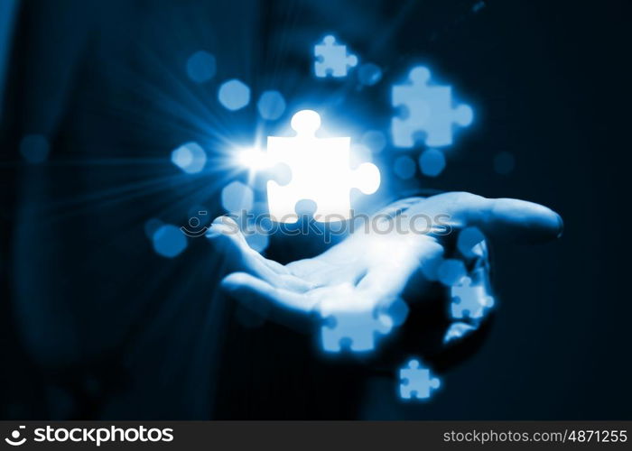 Puzzle elements in palm. Close up of businessman hand holding icons