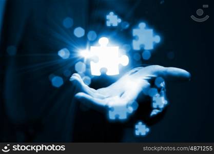 Puzzle elements in palm. Close up of businessman hand holding icons