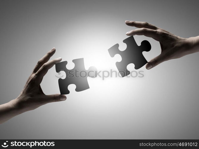 Puzzle game. Close up of human hands connecting puzzle elements