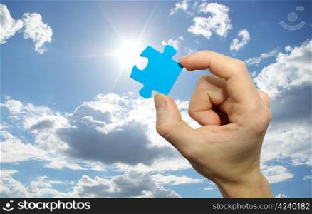 puzzle in hand isolated on sky background