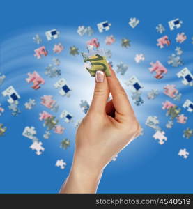 Puzzle of the euro banknotes and hands which it is collected. Symbol of business