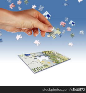Puzzle of the euro banknotes and hands which it is collected. Symbol of business
