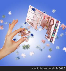 Puzzle of the euro banknotes and hands which it is collected. Symbol of business