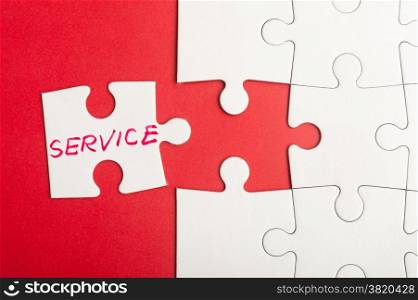 Puzzle piece which written service word inserted into group of white paper jigsaw puzzles