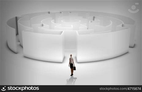 Puzzled businesswoman standing near entrance of labyrinth
