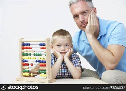 Puzzled Father And Son Looking Abacus