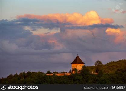 Pyatnychany tower  defense structure, 15th century  on evening twilight forest hill slope, Lviv Region, Ukraine.
