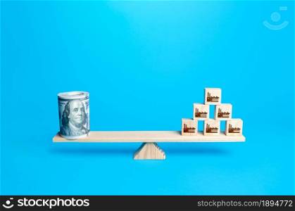 Pyramid of blocks with industrial factories and a dollars bundle money on scales. Subsidies financial support for medium and large businesses and manufacturers. Supporting economy and preserving jobs.