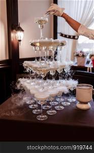 Pyramid of champagne glasses with liquid nitrogen. Champagne glasses with sparkling wine in the pyramid. Glasses with alcoholic. Pyramid of champagne glasses with liquid nitrogen. Champagne glasses with sparkling wine in the pyramid
