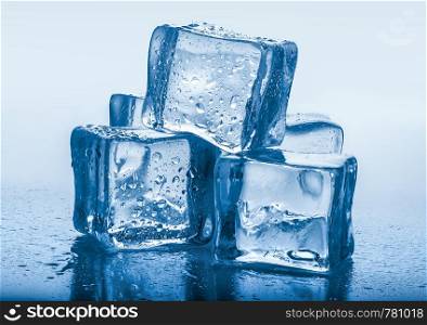 Pyramid of ice cubes on a blue background. Ice cubes on blue