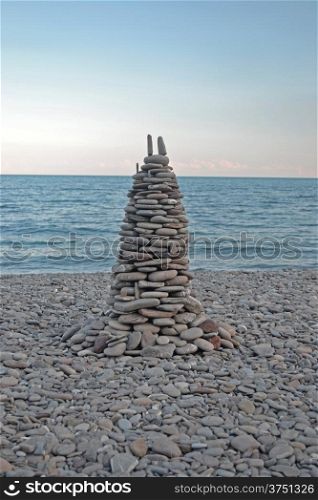 pyramid of stones on the beach during sunset
