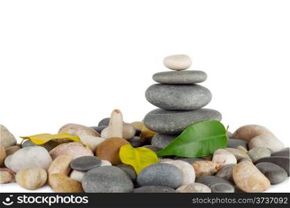 Pyramid of the round sea stones with leaves isolated on white background