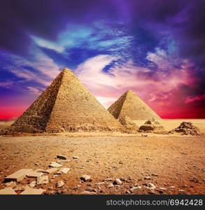 Pyramids in desert under ultra violet clouds