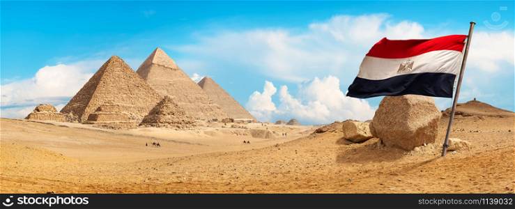 Pyramids of Giza in the desert and flag
