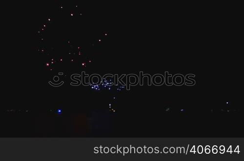 Pyrotechnics in Chicago downtown reflected on the lake waters. Celebration rockets in the dark sky with reflections on the water. Bright shiny rocket explosions in the dark. Fantasy beautiful decorations in the sky.