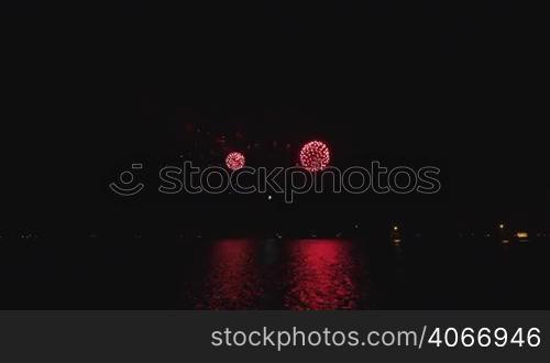 Pyrotechnics in Chicago downtown reflected on the lake waters. Celebration rockets in the dark sky with reflections on the water. Bright shiny rocket explosions in the dark. Fantasy beautiful decorations in the sky.