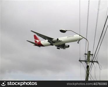 Qantas jet under view as it comes into land. Landing close to built up area. Shot December 01..