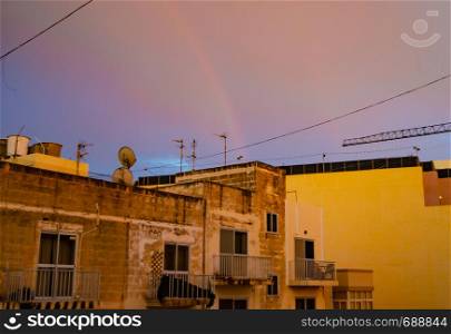 Qawra, Malta 30. may 2019 - rainbow over the residential buildings.. Qawra, Malta 30. may 2019 - rainbow over the residential buildings