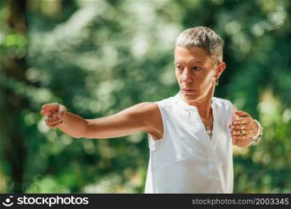"Qi Gong Female Expert Doing Qigong Exercises Outdoor for Moving "Chi" or Energy in the Body"