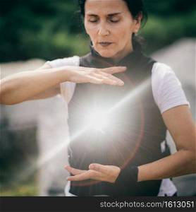 Qi Gong training outdoors, woman’s hands in focus.. Chi Gong Practice