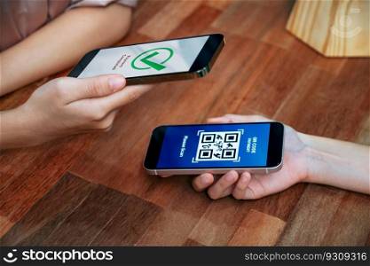 QR code is displayed on screen for cashless payment scanning. Closeup hands hold smartphone to transfer money by electronic transaction from mobile app. Bar code technology for fast pay. Enthusiastic. QR code is displayed on screen for cashless payment scanning. Enthusiastic