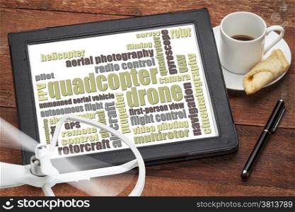 quadcopter drone word cloud on a digital tablet with a cup of coffee and rotating drone propeller