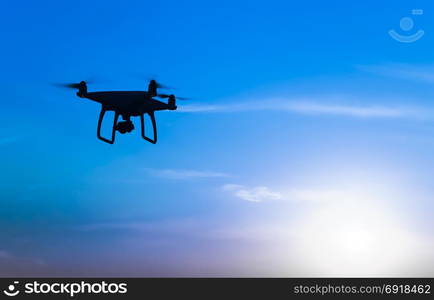 Quadrocopters silhouette against the background of the sunrise. Flying drones in the evening sky.. Quadrocopters silhouette against the background of the sunrise