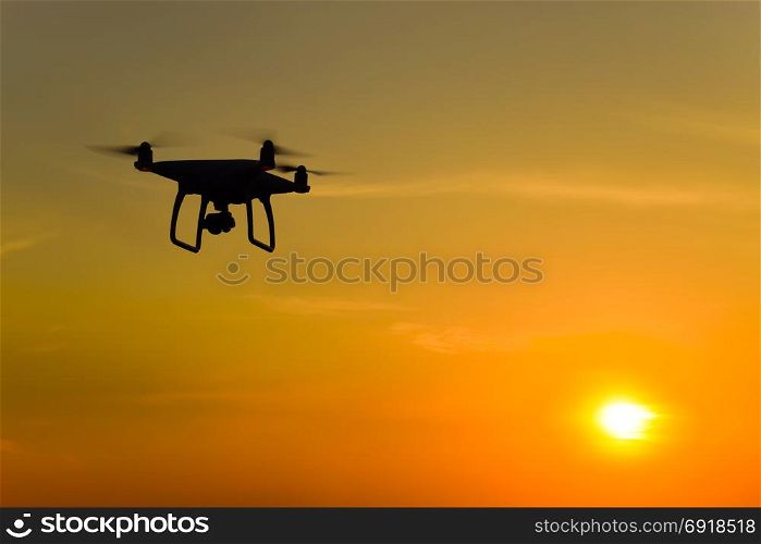 Quadrocopters silhouette against the background of the sunset. Flying drones in the evening sky.. Quadrocopters silhouette against the background of the sunset. Flying drones in the evening sky