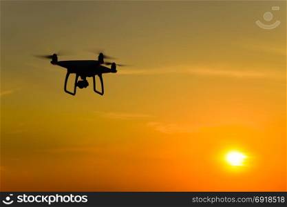 Quadrocopters silhouette against the background of the sunset. Flying drones in the evening sky.. Quadrocopters silhouette against the background of the sunset. Flying drones in the evening sky